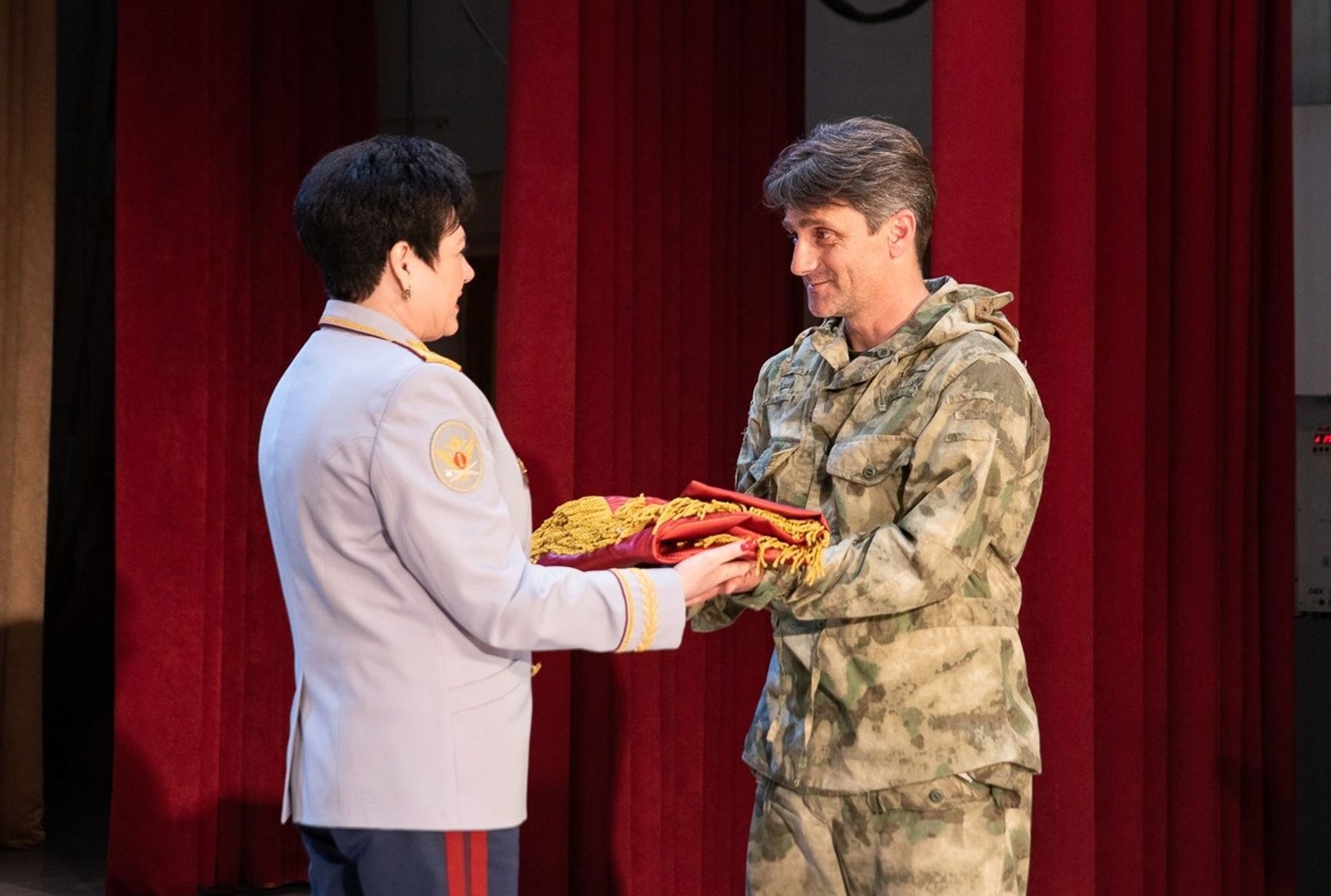 General Zarembinska presents the banner to Serbian mercenary Dejan Beric